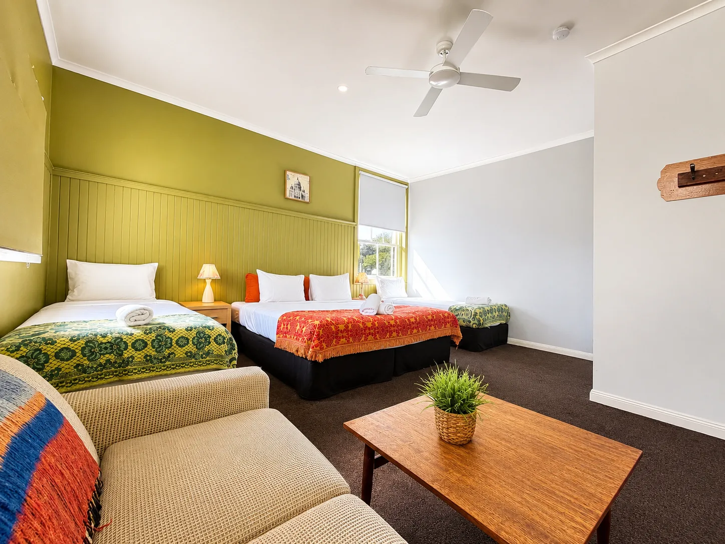 Bedroom with colourful bedding and sofa — Family Room at Vine Valley Inn Cessnock