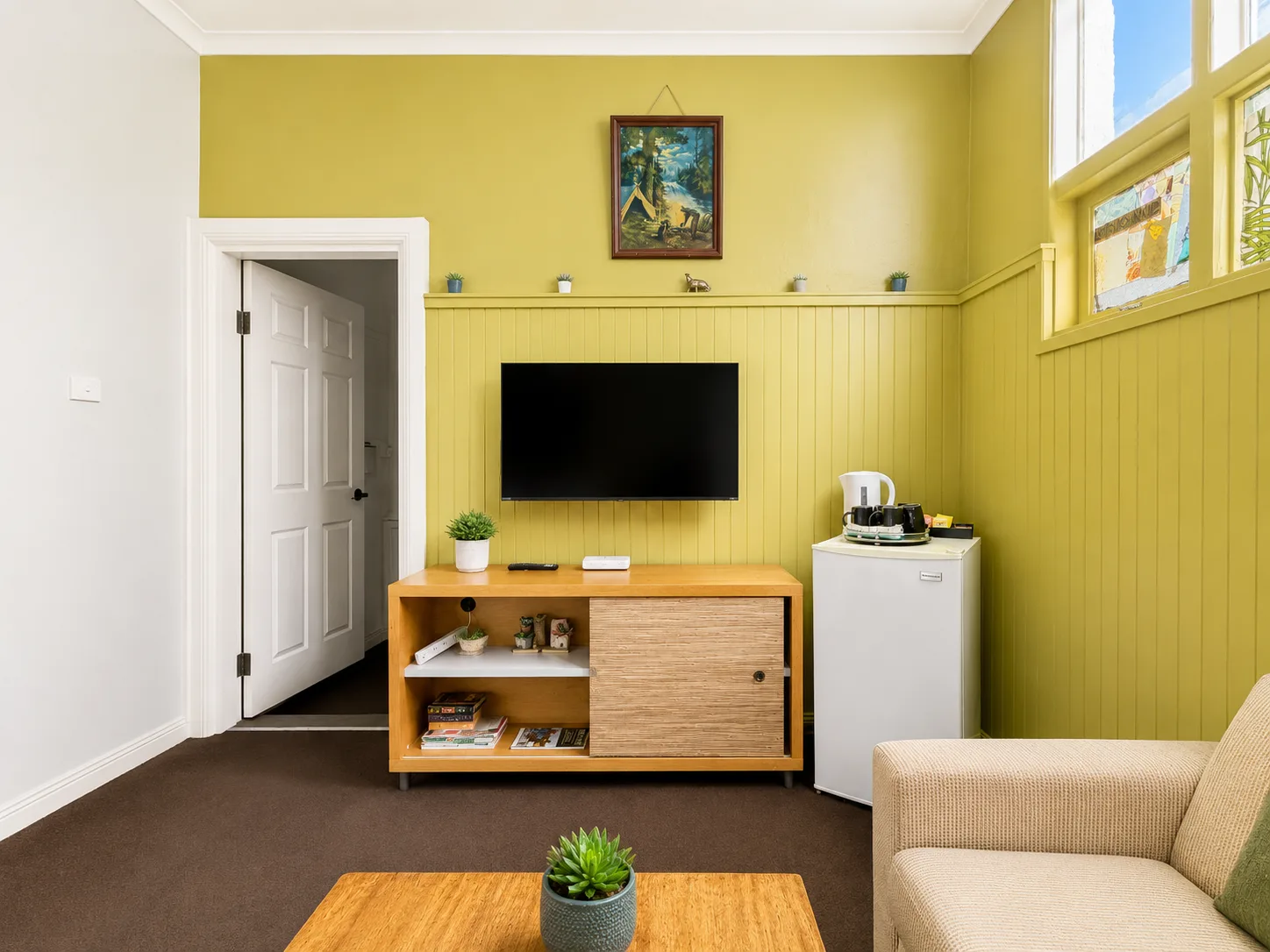 Lounge area with TV and kitchenette — Family Room at Vine Valley Inn Cessnock