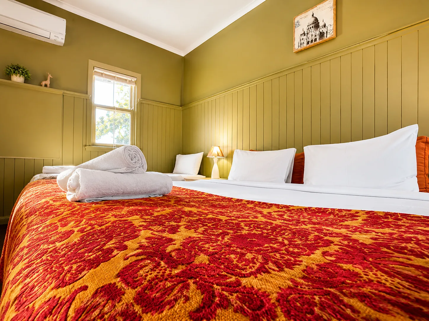 Queen bed with fresh towels — Family Room at Vine Valley Inn Cessnock