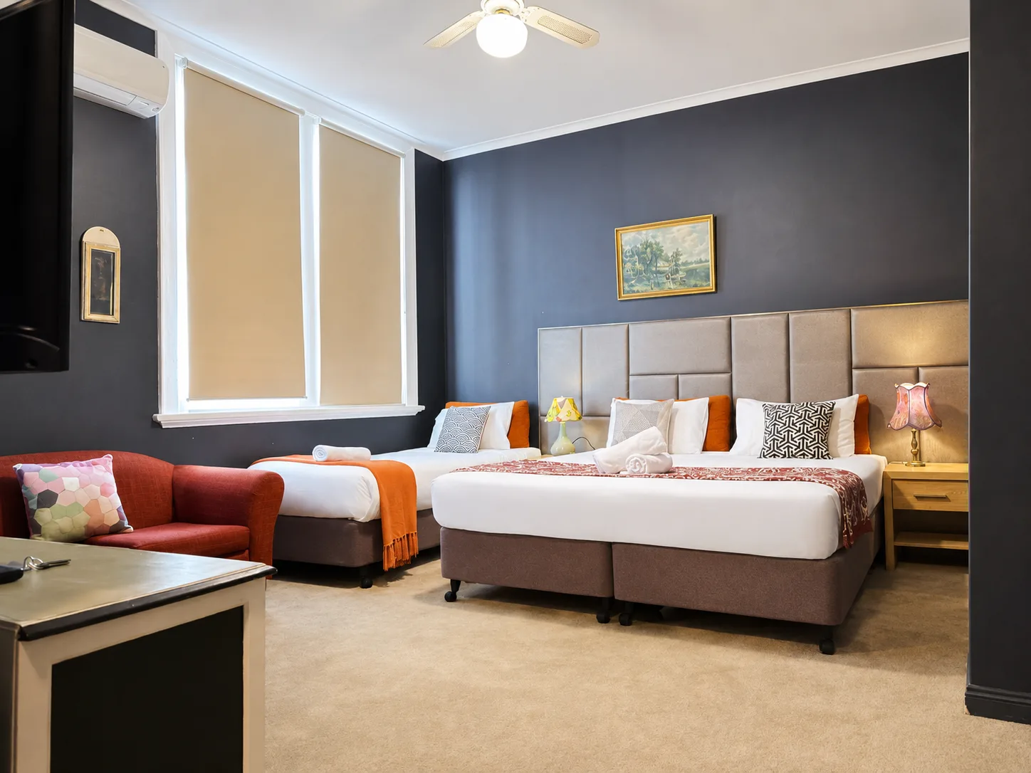 Lounge seating with twin and queen beds — Twin Room at Vine Valley Inn Cessnock